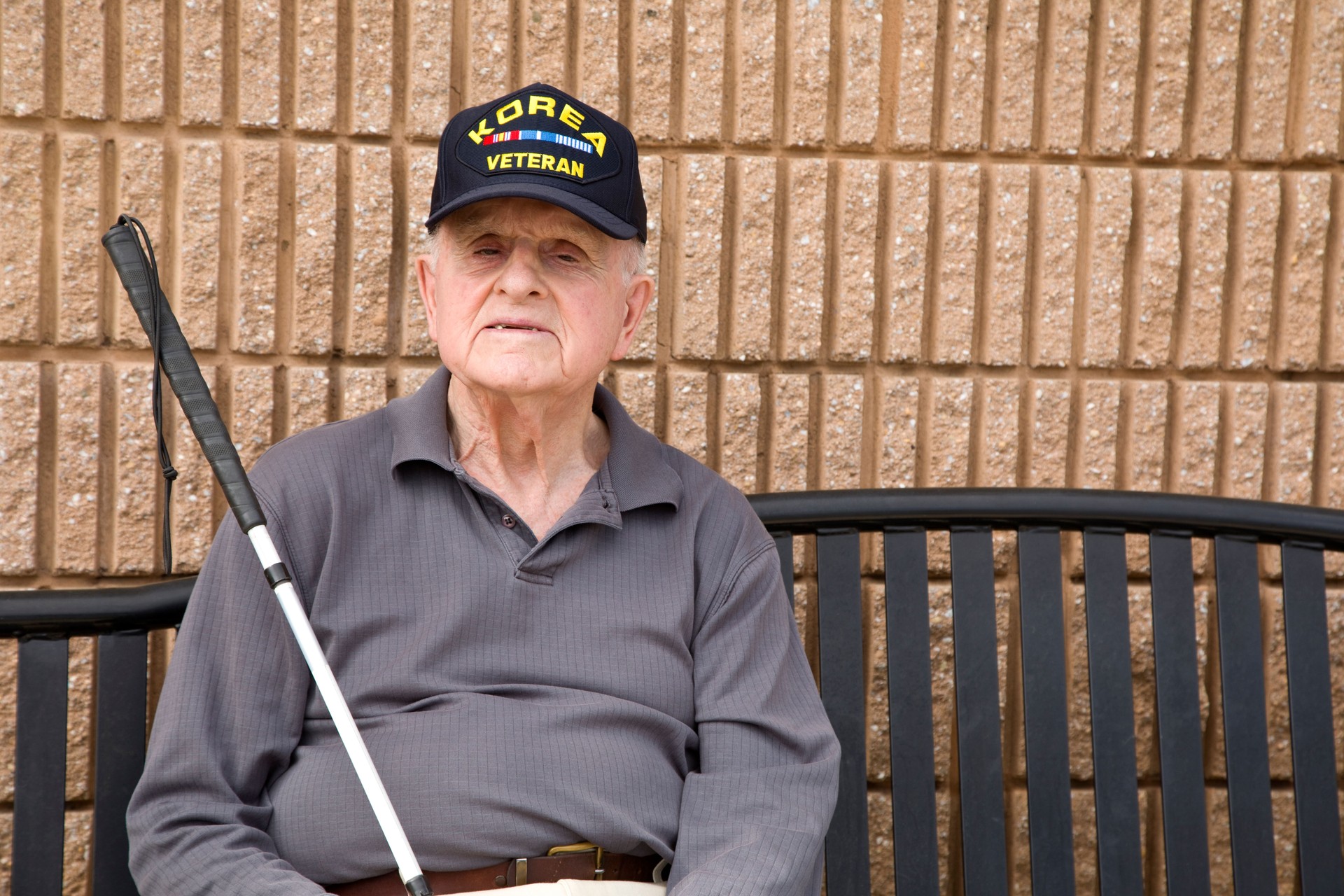Blind Korean War veteran sitting on bench